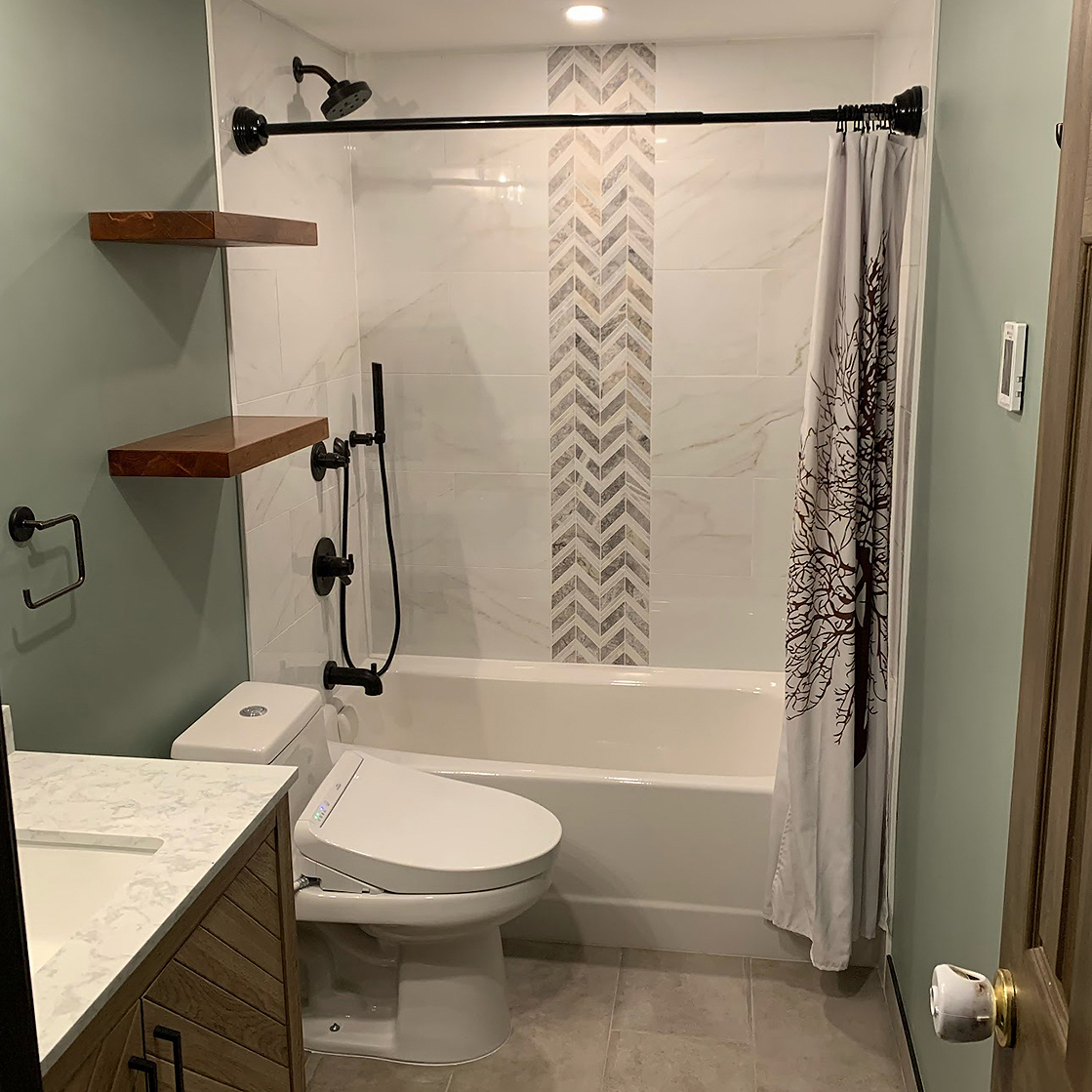 Bright bathroom featuring white subway tile, black fixtures, and a custom shower niche.