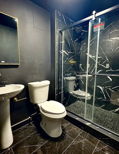Walk-in shower with frameless glass, floor tile, and built-in bench in a Denver area remodel.