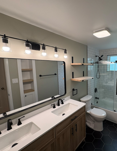 Spa-style bathroom remodel with freestanding tub, large window, and tiled accent wall.