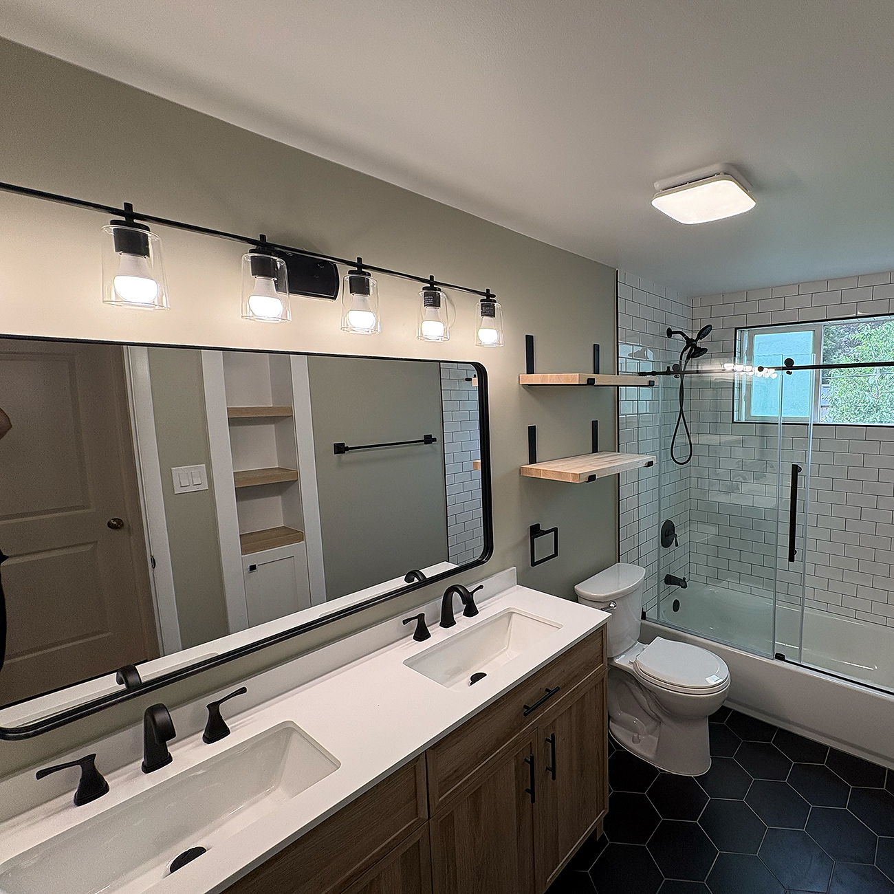 Spa-style bathroom remodel with freestanding tub, large window, and tiled accent wall.